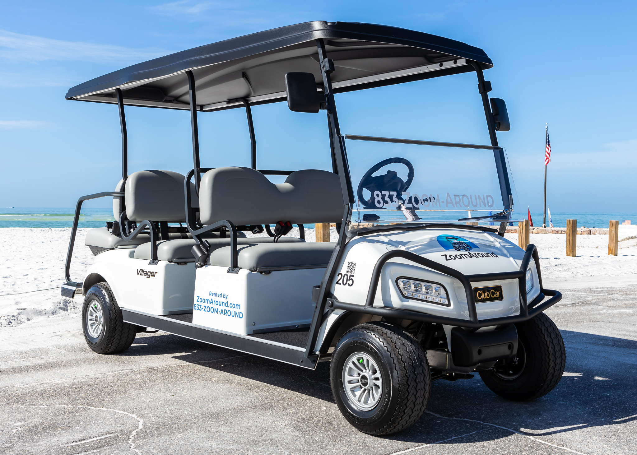 6 Pass Villager 205 Right Front Angle (2) A white and black golf cart parked on the beach.